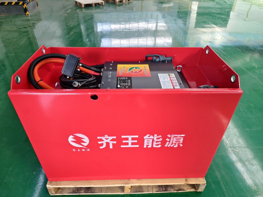 Red LiFePO4 traction pack in a steel enclosure, three-quarter view on a pallet